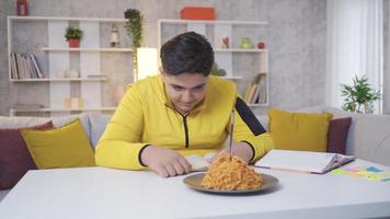 menino obeso prestando atenção à sua alimentação. a criança que quer comer macarrão se contém e não come. video