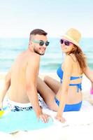 Young couple sitting on the beach photo