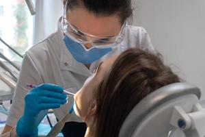 dentist treats teeth to a girl in a clinic photo