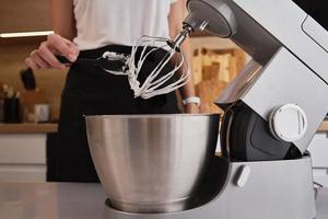 Woman using food processor to cooking in kitchen photo