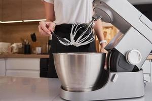 Woman using food processor to cooking in kitchen photo