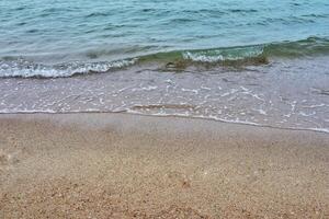 Sea coast and moving wave at the sandy beach for background and inspirational text. photo