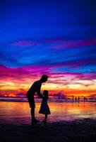 Father and daughter silhouettes in sunset at the beach on Boracay, Philippines photo