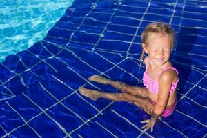 Adorable happy little girl enjoy swimming in the pool photo