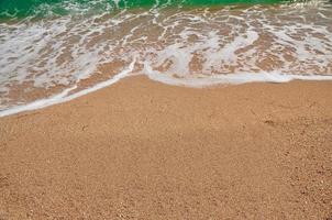 Sea wave rushed to the sandy beach. Summer travel photo