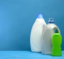 plastic bottles with detergents on blue background photo