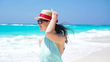 lindo mulher em verão feriados sorridente feliz em branco de praia. feliz menina caminhando dentro verão vestir. lento movimento video