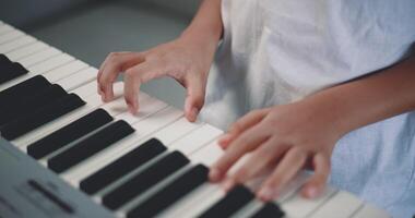 fechar-se mão do criativo ásia Garoto com artístico Habilidades levando música lições conectados durante uma vídeo ligar e jogando a piano às lar. música, passatempo e estilo de vida conceitos. video