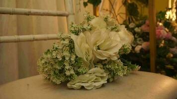 a bouquet of flowers on a white chair with camera movement, used as a prop for engagement and wedding photos. video