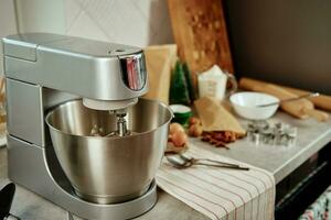 Electric mixer kneads dough in the kitchen photo