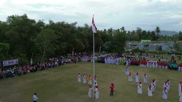 Gorontalo, Indonesia - August 17, 2023 - Aerial view of the elderly acted as officers of the Indonesian independence ceremony. The Indonesian flag lowering ceremony witnessed by villagers video