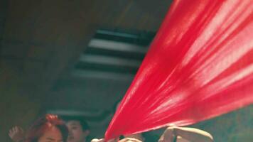 a group of Asian dancers dance with red cloth ties around their bodies video