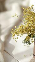 a small vase with yellow flowers on a table video