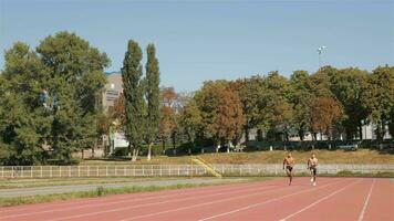 Two athlets sprinting at the stadium video