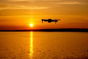 Drone flying at the sunset moment. Drone quadcopter with digital camera flying at sunset photo