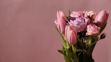 Spring flowers tulip, rose on a pink background that rotate, close-up, copy space for international Women's Day. Bouquet for mother, wife, sister, daughter, grandmother video