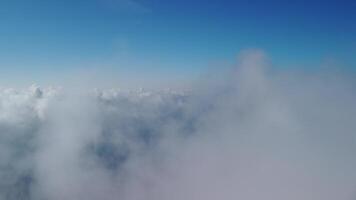 Aerial view. The drone flies over foggy and fluffy clouds. Blue sky sun and sea fog. Abstract aerial nature summer ocean sunset sea and sky background. Vacation, vacation and holiday concept video