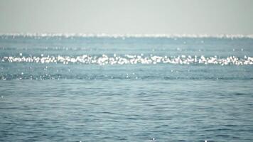 Sea water surface. Low angle view over clear azure sea water. Sun glare. Abstract nautical summer ocean nature. Holiday, vacation and travel concept. Nobody. Slow motion. Weather and climate change video