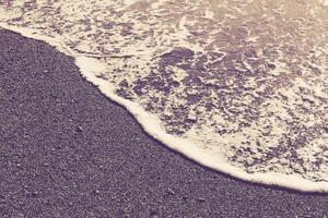 Beach sand with sea wave foam. Marine summer background. photo