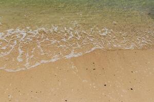 Sea surf on the beach with sand. photo