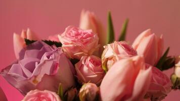 A close-up vertical plan of a summer pink bouquet of flowers. Tulips and roses on a neon background with copy space, paste text video