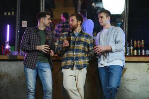 Friends resting in the pub with beer in hands. Having conversation. photo