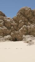 A group of rocks sitting on top of a sandy beach video