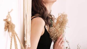 Young woman holding a bouquet of dry flowers in her hands video