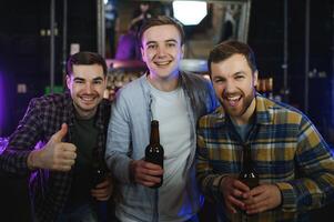 Friends resting in the pub with beer in hands. Having conversation. photo