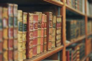 Blurred bookshelf background with many books in library. photo