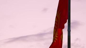 Close up slow motion The national flag of Kyrgyzstan waving. Consists of a red field charged with a yellow sun that contains a depiction of a tunduk, the opening in the center of the roof of a yurt video