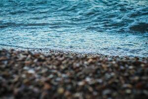 Wave running onto the coast. Foreground is blurred and focus is on the sea water. Natural background. photo