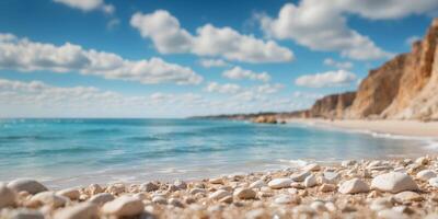 A sandy beach nestled by a rocky cliff, beneath a blue sky adorned with white, fluffy clouds, and a crystalline body of water. photo