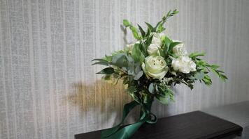 Bouquet of white roses flowers. Wedding bouquet of bride on sofa. Morning preparations of newlyweds video