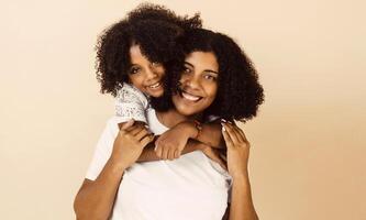 afro americano madre y hija sonriente contento abrazando terminado aislado antecedentes. foto