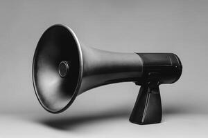 Black Megaphone with Curved Horn and Handle on Grey Background photo