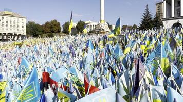 Many small blue-yellow flags with names of the dead war against russia. Memorial of the fallen soldiers, children, women in the capital of Ukraine. Concept of tragedy and misfortune. Close up video