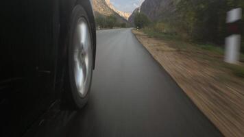 Car driving on wet asphalt road at street. Close up of vehicle wheel with tire in motion on rainy day video