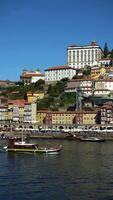 porto cidade, douro rio em ensolarado dia. episcopal Palácio e histórico Centro. Portugal. barco é passagem por. vertical video