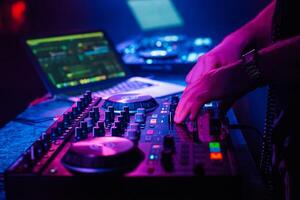 DJ mixes electronic music with his hands on a music controller photo