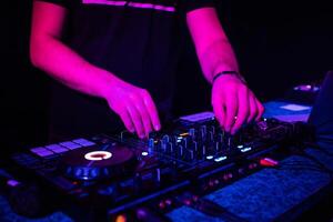 DJ mixes electronic music with his hands on a music controller photo