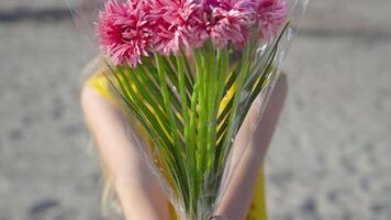 Teenager holds a bouquet of flowers in hand and looks forward with serious look video