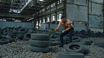 Man train with hammer and tires. Strong muscular man with perfect body training with big sledgehammer video