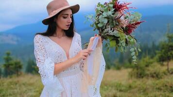 Woman posing on top of mountains. Pretty long haired girl in wedding dress on mountain meadow video