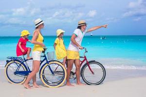 família andando de bicicleta em praia tropical foto