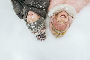 retrato do dois irmãos deitado em neve foto