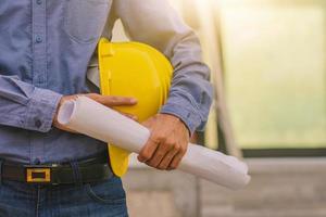 Architekturingenieur mit Schutzhelm vor Ort Bauhintergrund foto