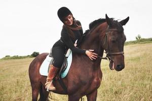 junges hübsches Mädchen - Reiten, Pferdesport im Frühling foto