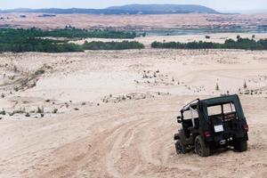 jeep bil med vit sandstrand. vietnam öken, populär turist attraktioner i söder av vietnam. foto