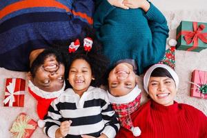 afrikansk amerikansk familj i jultema. lycklig afroamerikansk familj på fyra bonding liggande på golvet tillsammans. foto